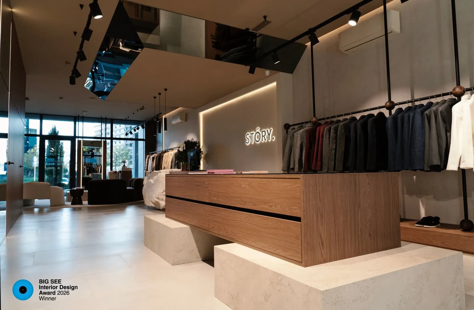 Butik STORY sa pultom od orahovog drveta na kamenim postoljima, ogledalskim plafonom i osvijetljenim logotipom, projekat ALISA DESIGN