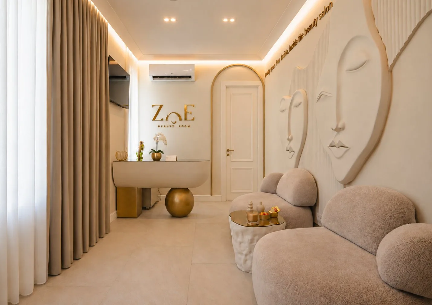 Recepcija salona ljepote ZOE sa zaobljenim pultom na zlatnoj kugli, lučnim vratima i reljefnim licima na zidu, projekat ALISA DESIGN